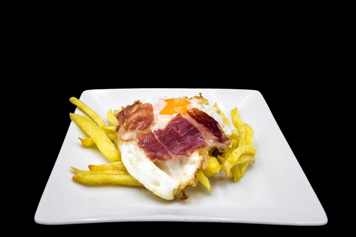Fried egg with potatoes and Iberian ham