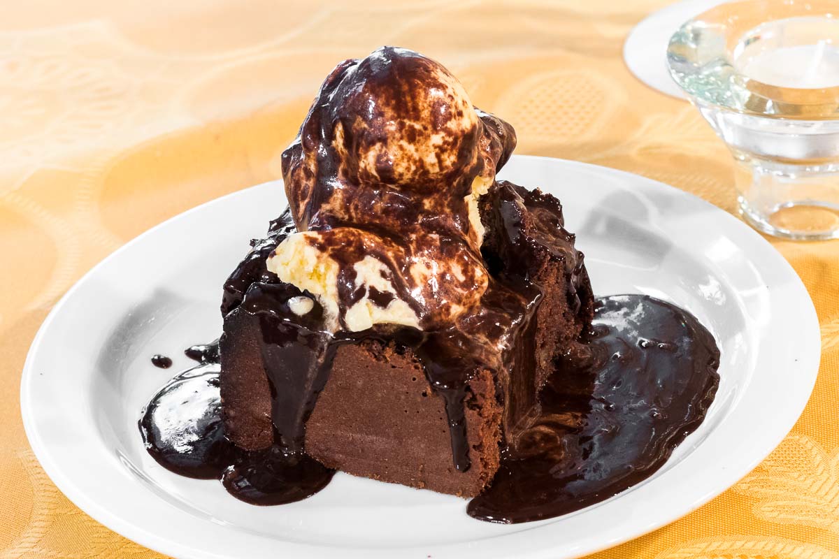 Brownie casero con helado y chocolate caliente