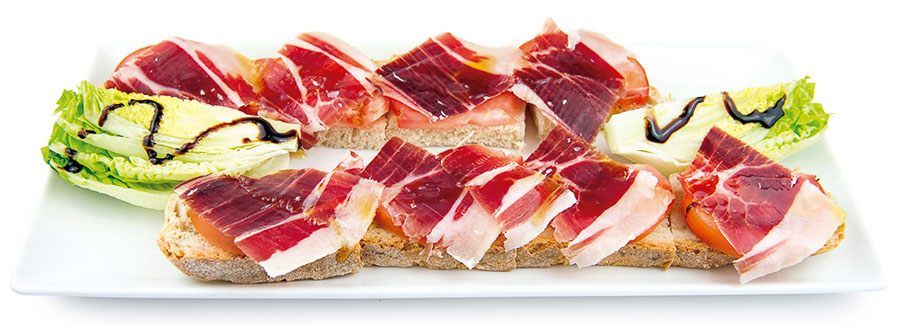 Sliced ham, tomato and olive oil on toast