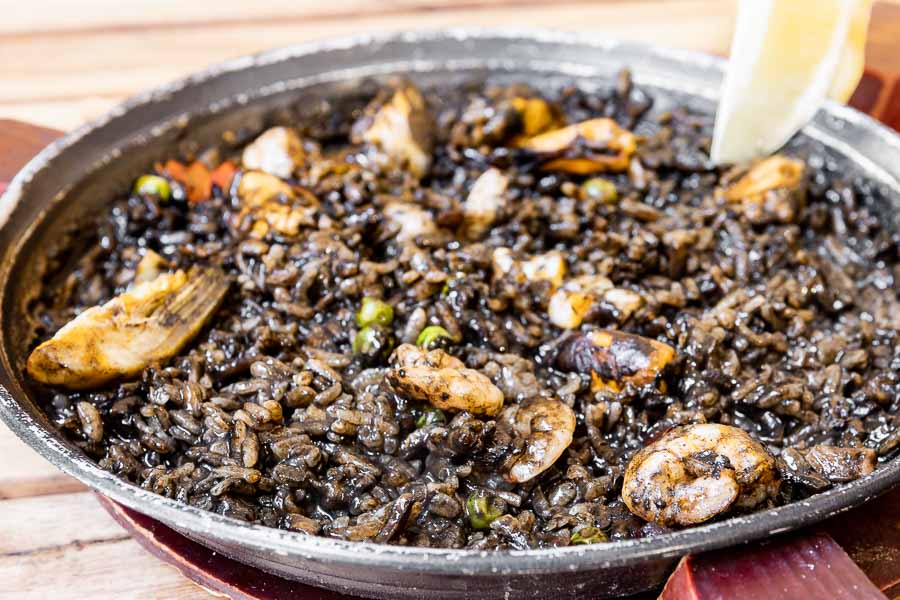 Paella with black rice and fish