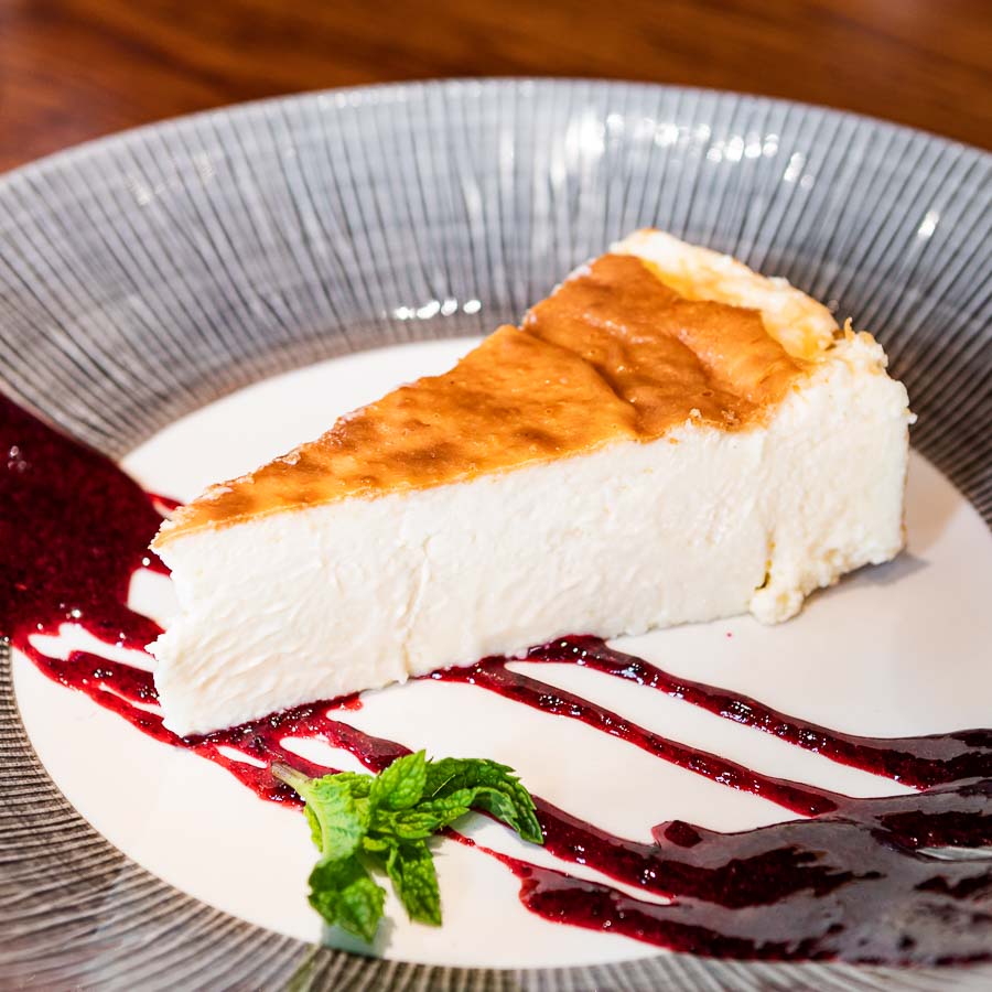 Baked cheesecake served w/ red fruit coulis