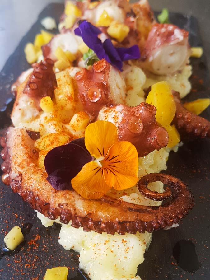 Grilled octopus with mashed potatoes and mango