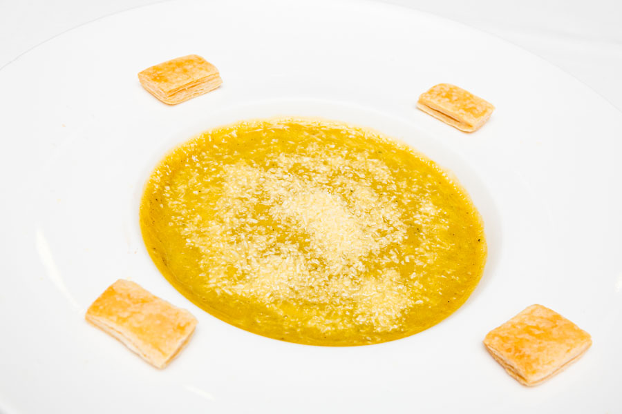 Vegetables cream soup with curry, coconut and croutons of puff pastry