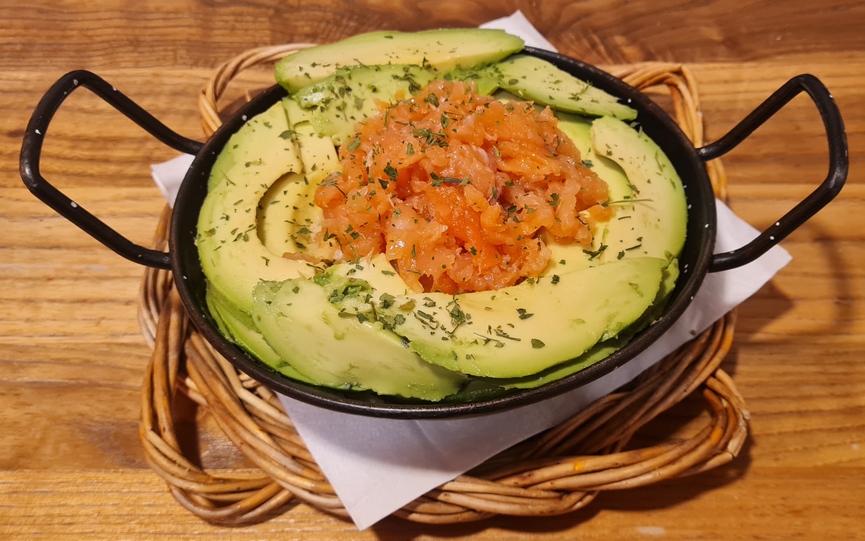 Scrambled eggs with potatoes and onion, topped with avocado and smoked salmon
