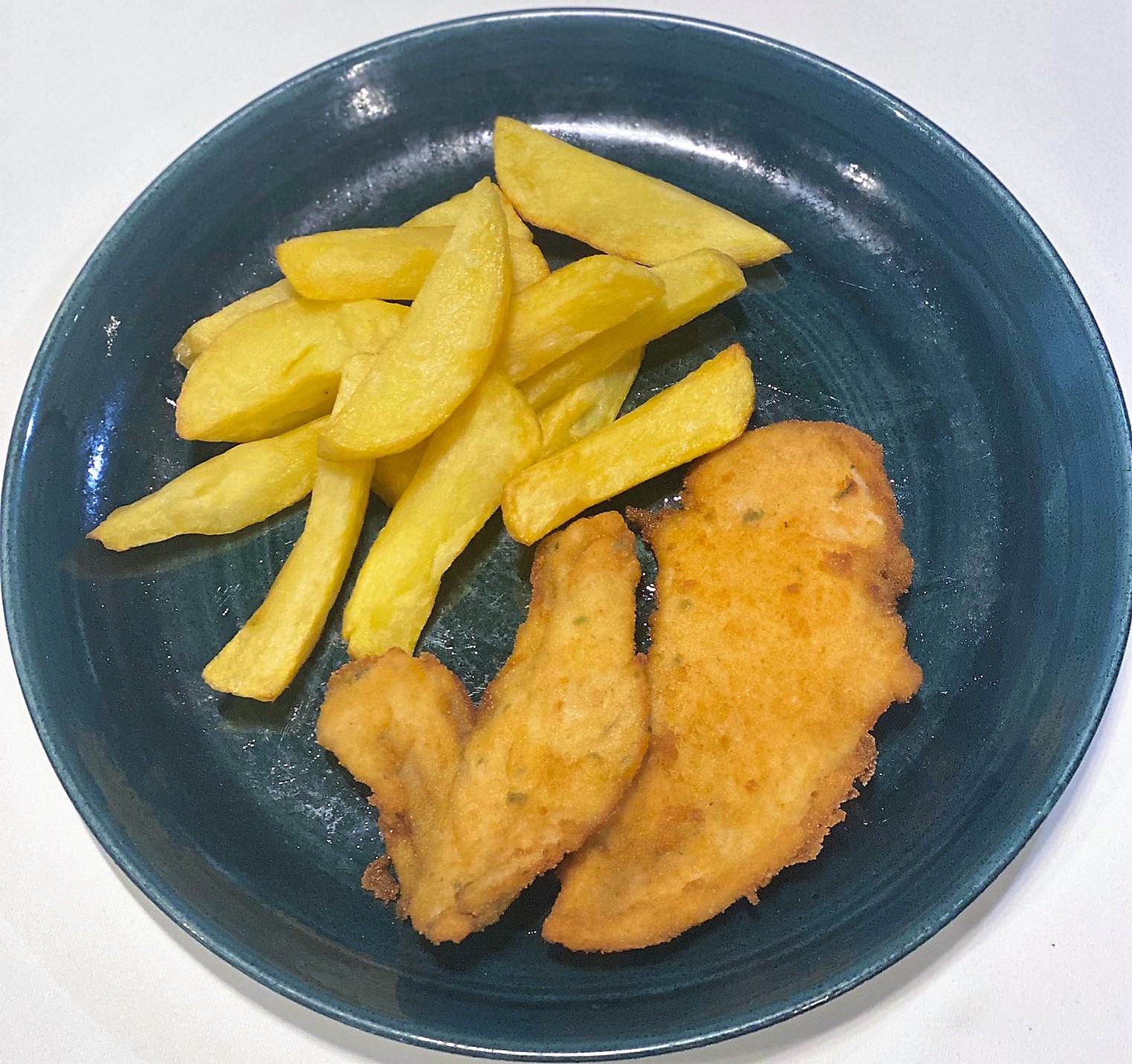 Plate of breaded chicken fillet with fries