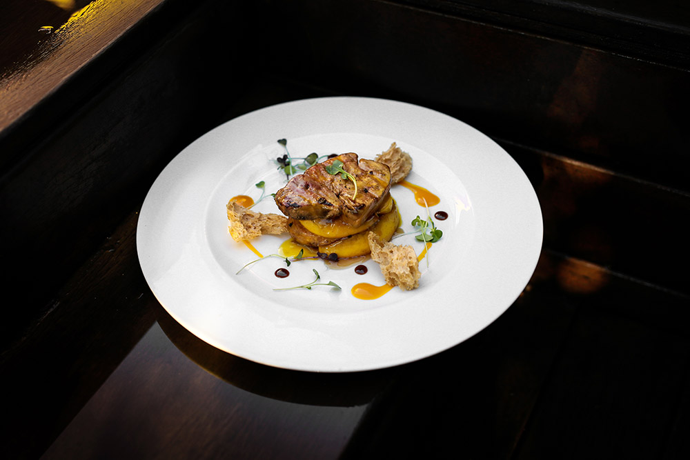 Foie gras grigliato con mela caramellata e mango con pietre di vino dolce
