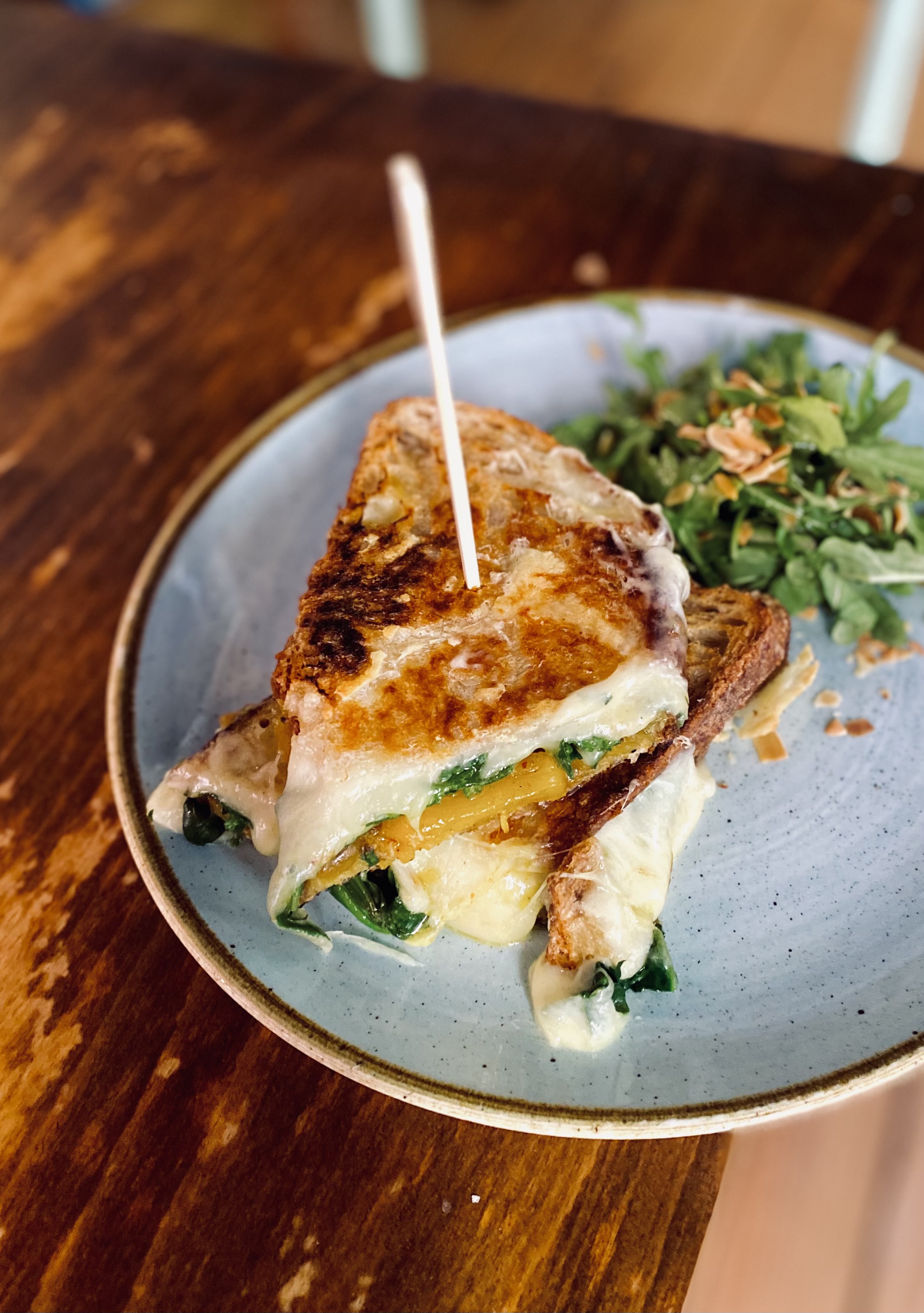 GRILLED CHEESE: Hot sandwich with a homemade sweet onion and pineapple chutney, spinach, gouda. Served with arugula