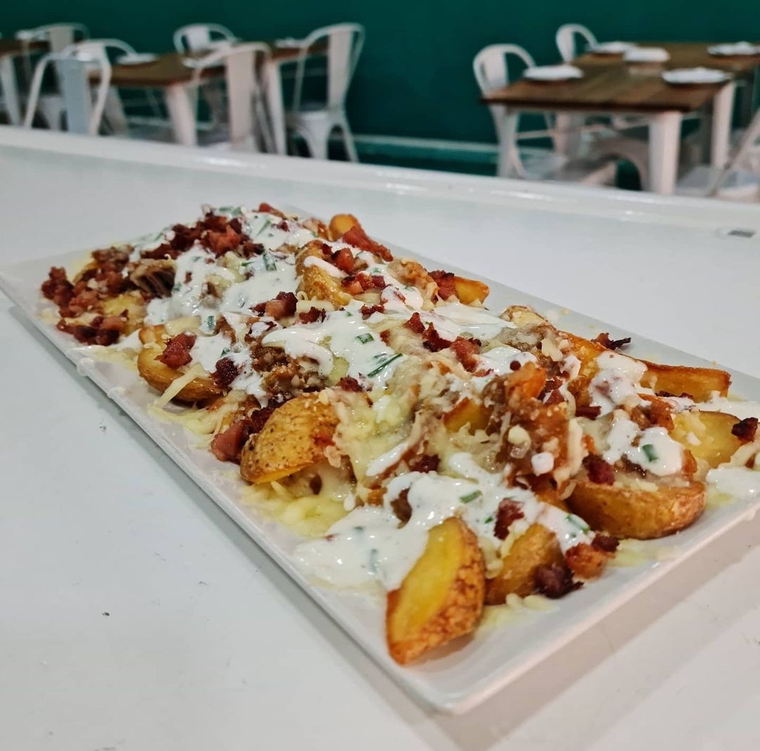 Potatoes between tides (potato wedges, ranch sauce, pulled pork and mozzarella cheese)