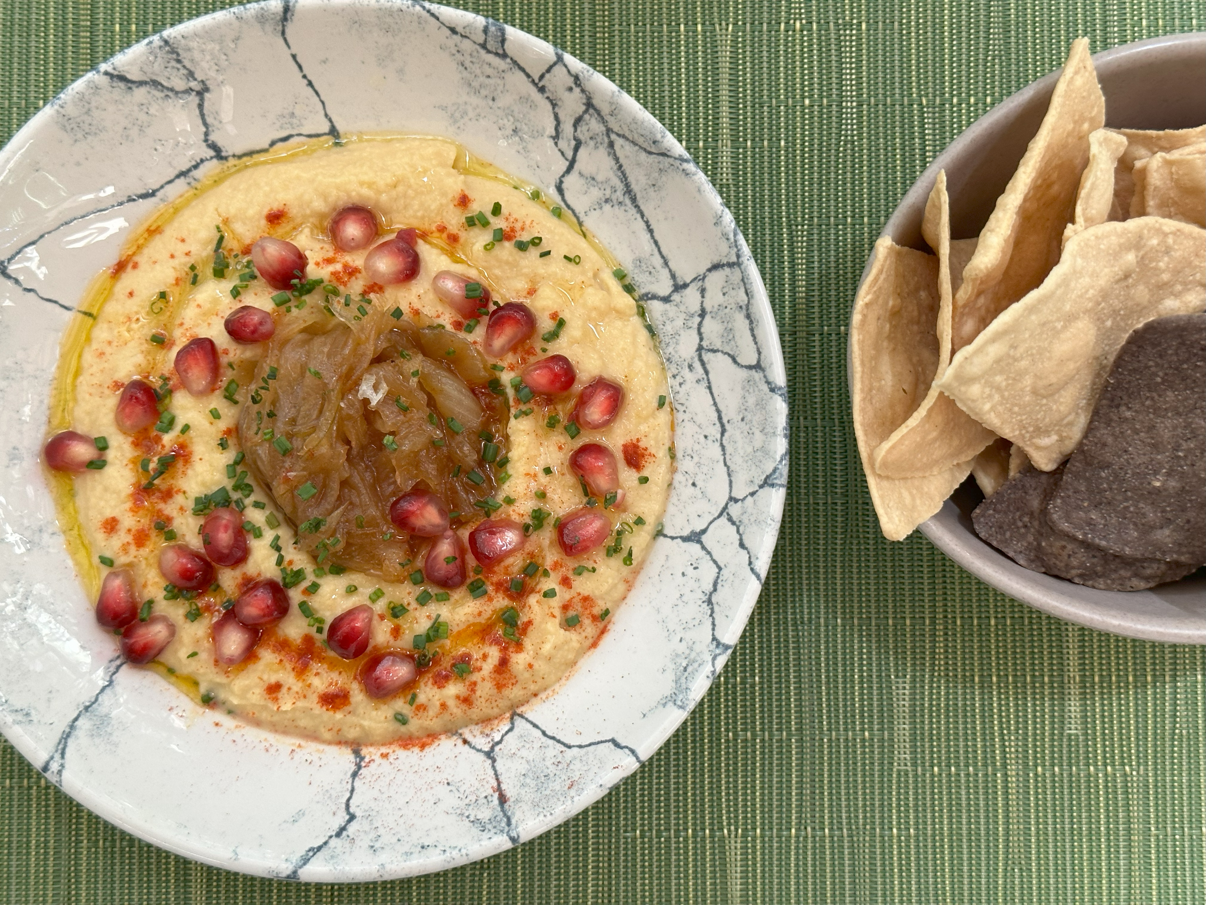 Hummus with caramelized onion, pomegranate and pita bread