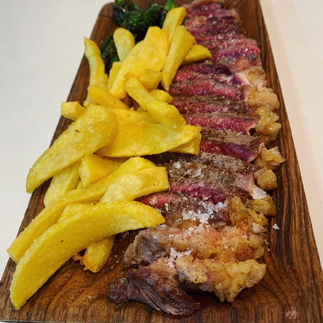 Beef entrecôte with french fries and fried green peppers