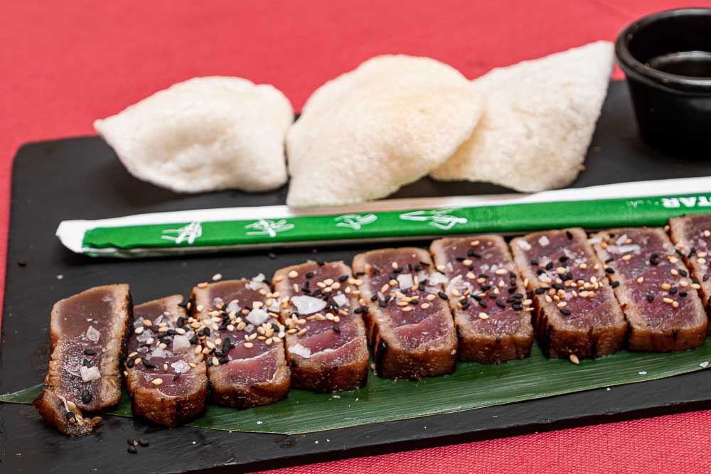 Tataki de atún rojo macerado en soja y vinagre de arroz sobre hoja de bambú con dúo de sésamo y pan de gamba
