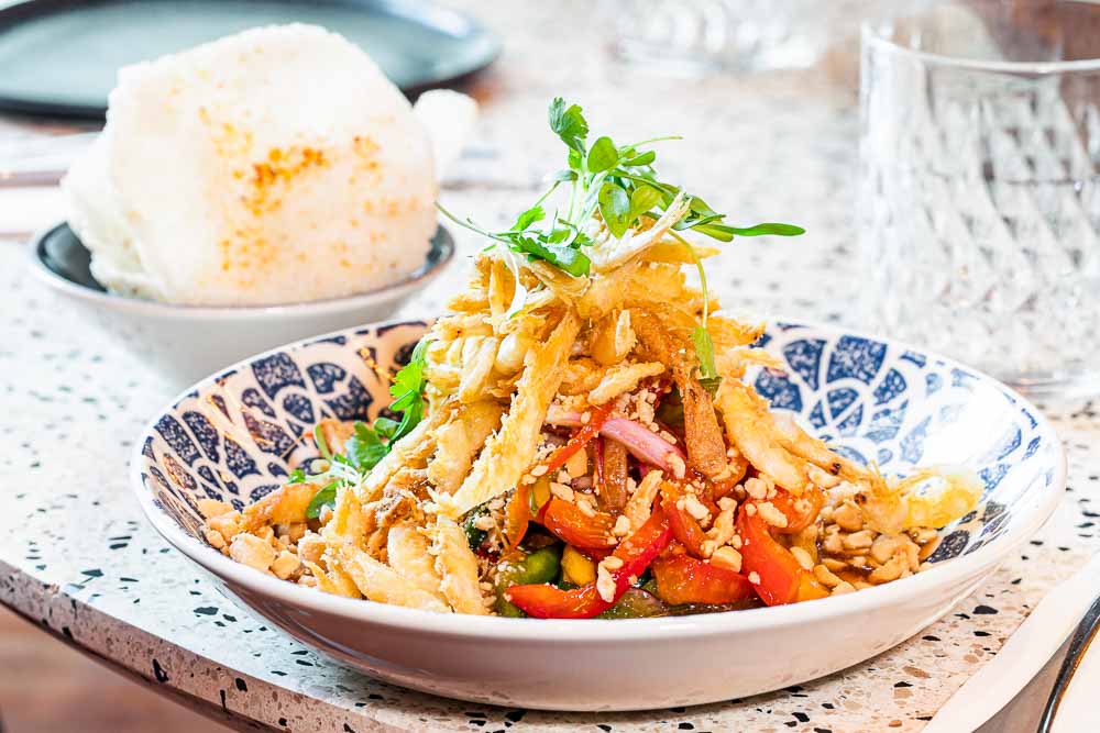 Salade thai froide aigre-piquante avec papaye, crevettes au lait frites et cacahuètes